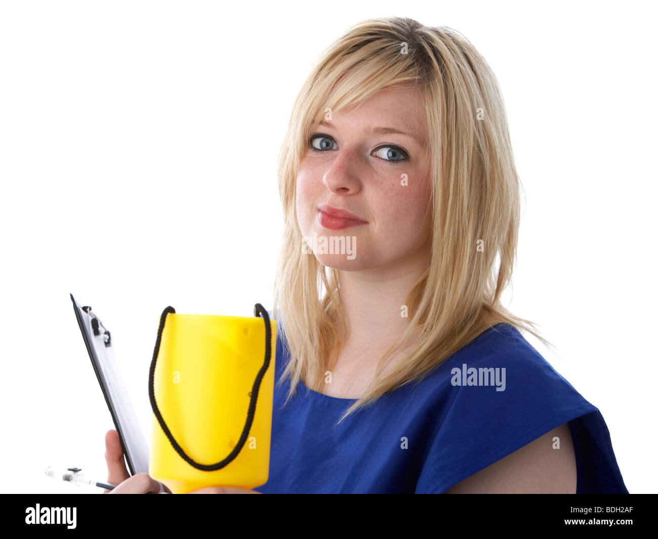 Jeune femme blonde de 20 ans portant un tabard bleu d'un organisme de bienfaisance worker holding out un boîte de collecte de charité Banque D'Images