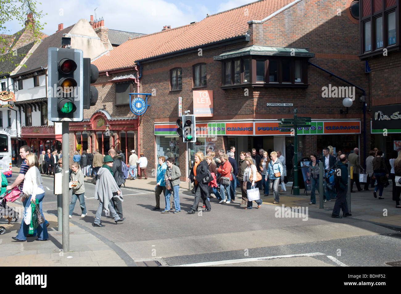 Les piétons qui traversent la route aux feux de circulation dans le centre-ville de York, Angleterre Banque D'Images