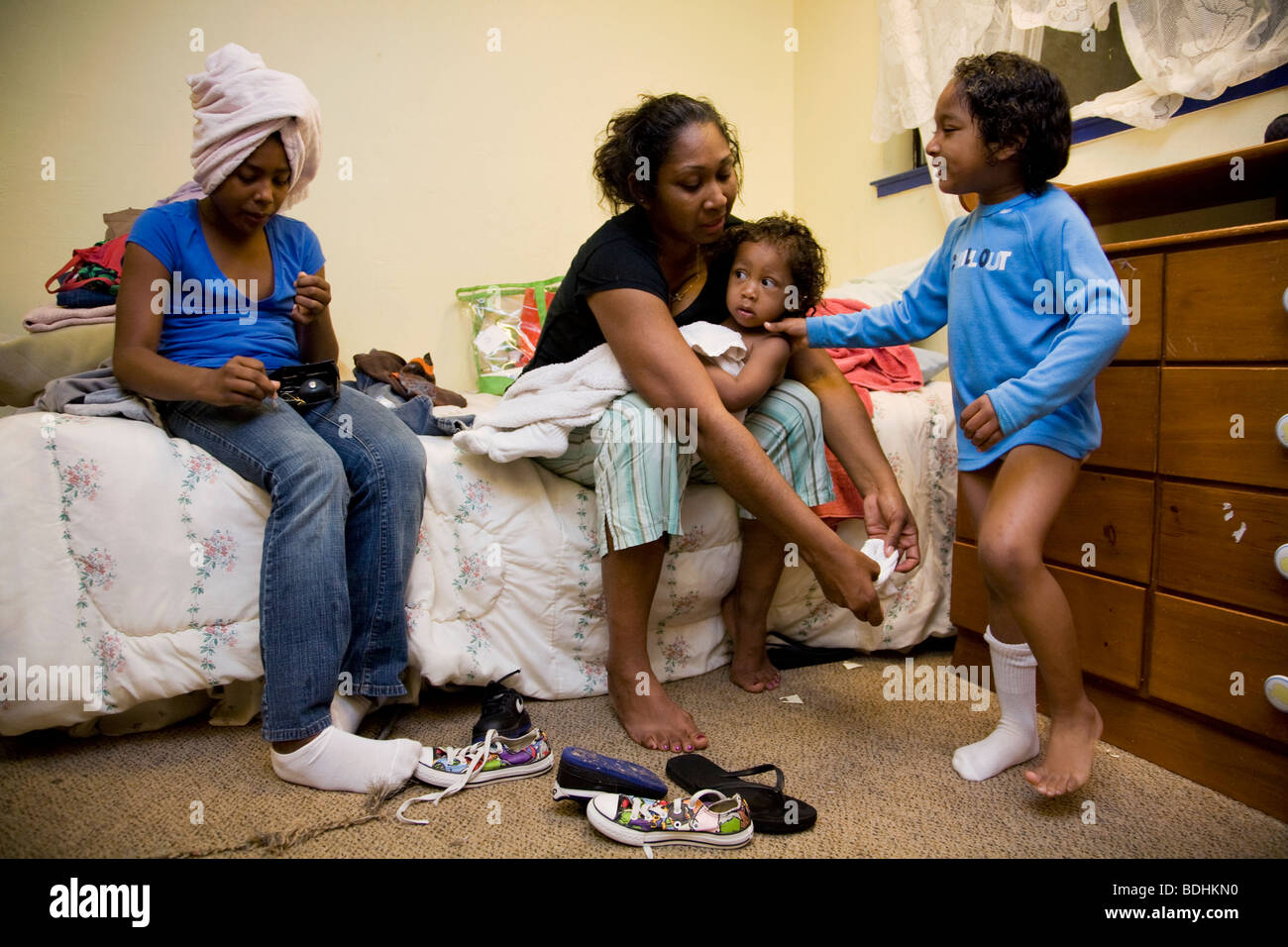 Selena Pina, un sans-abri, mère de quatre enfants s'habiller pour l'école à la famille Centre de promesses à Sacramento, CA. Banque D'Images