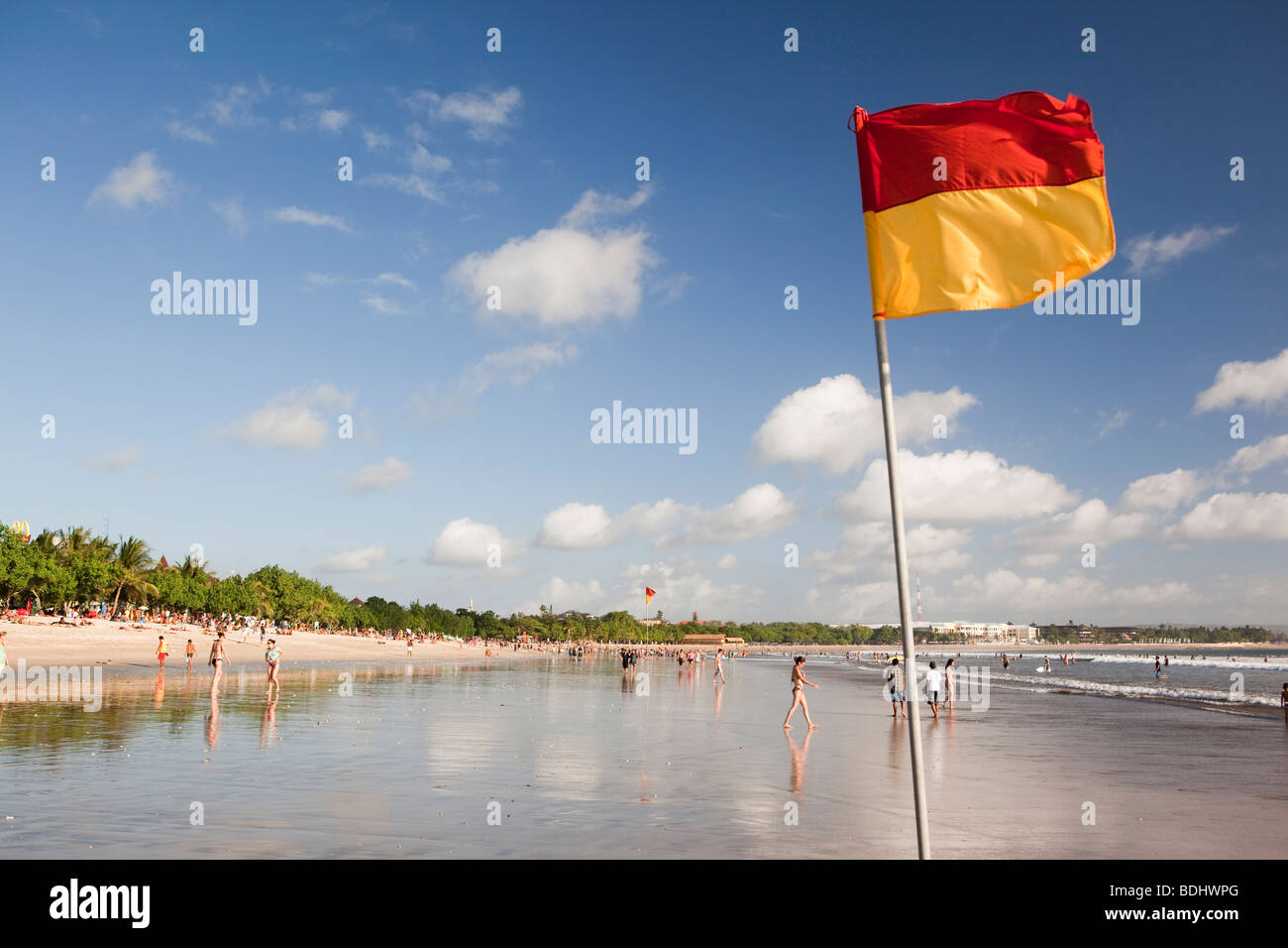 L'INDONÉSIE, Bali, Kuta, plage, jaune et rouge du drapeau de baignade sécuritaire survolant shallows Banque D'Images