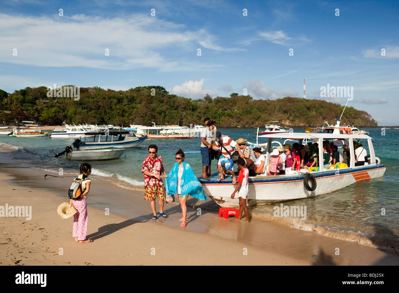 L'INDONÉSIE, Bali, Padangbai, touristes japonais au départ excursion bateau sur la plage Banque D'Images