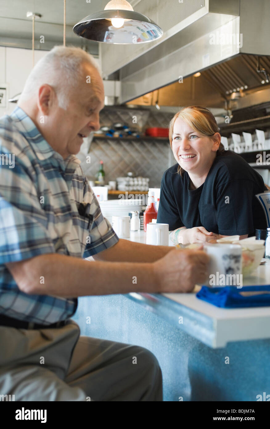 L'homme dans un café à discuter avec serveuse Banque D'Images L'homme dans un café à discuter avec serveuse Banque D'Images