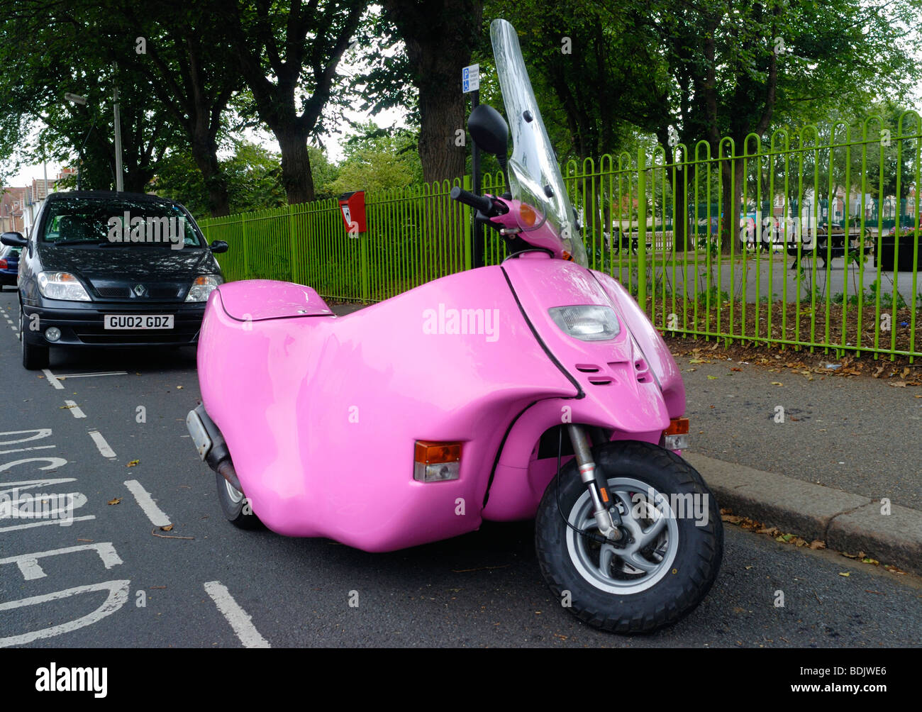 Une invalidité rose scooter garé dans une mobilité bay Banque D'Images