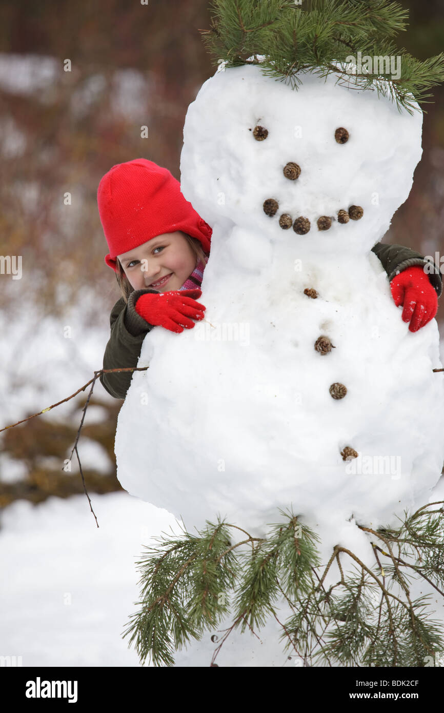 Portrait petite fille, heureux de poser avec le Snowman Banque D'Images