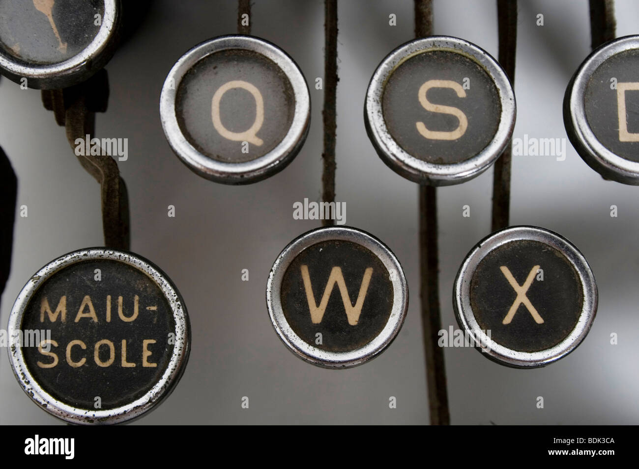 Touche noire avec lettres d'or d'une vieille machine à écrire, célèbre lettre en majuscule. Banque D'Images