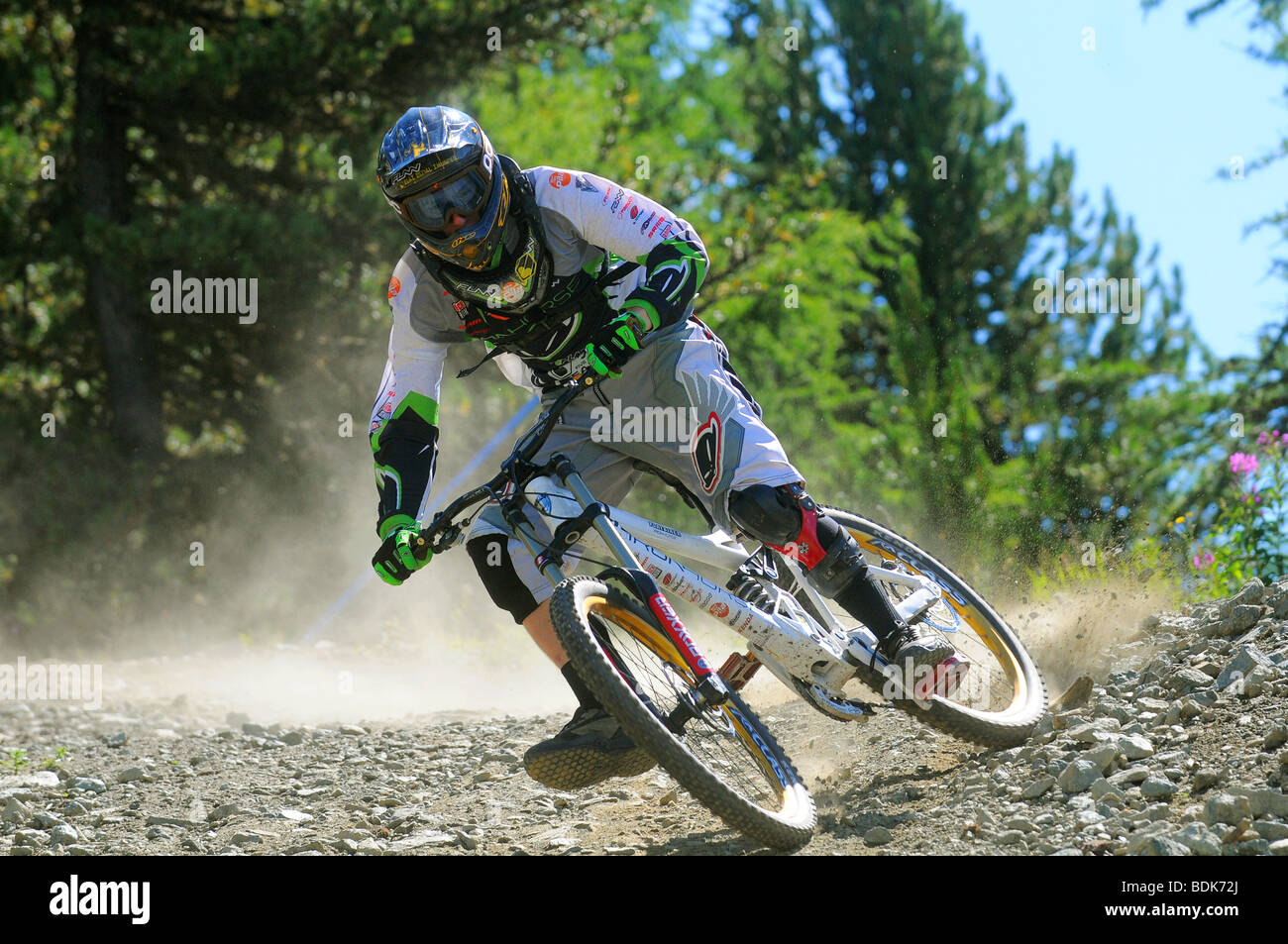 Une descente en vélo de montagne tourne à la vitesse sur un sentier rocheux dans un casque intégral et blindé à Pila dans les Alpes italiennes Banque D'Images
