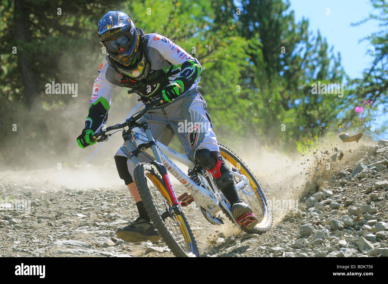 Une descente en vélo de montagne tourne à la vitesse sur un sentier rocheux dans un casque intégral et blindé à Pila dans les Alpes italiennes Banque D'Images