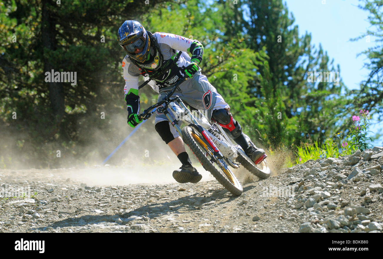 Une descente en vélo de montagne tourne à la vitesse sur un sentier rocheux dans un casque intégral et blindé à Pila dans les Alpes italiennes Banque D'Images