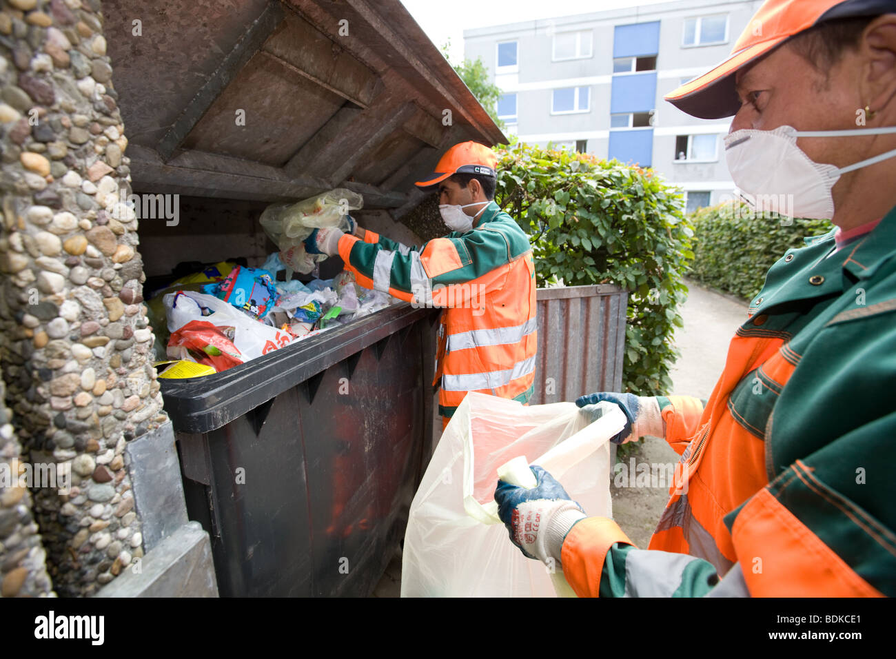 Deux travailleurs tri des déchets à un wheelie bin Banque D'Images Deux travailleurs tri des déchets à un wheelie bin Banque D'Images