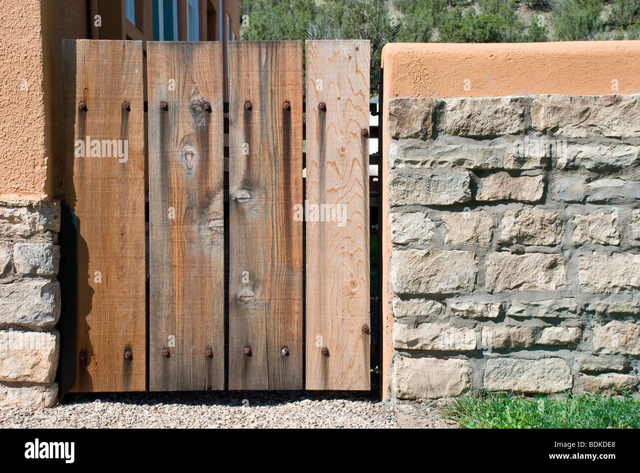 Une porte en bois rustique se trouve dans un mur de pierre d'adobe à l'ancienne école historique de Lincoln, Nouveau Mexique. Banque D'Images