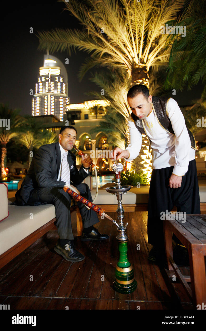 Dubaï, Emirats Arabes Unis : Le Palace Hotel au centre ville de Dubaï, les hommes fument une pipe à eau. Banque D'Images