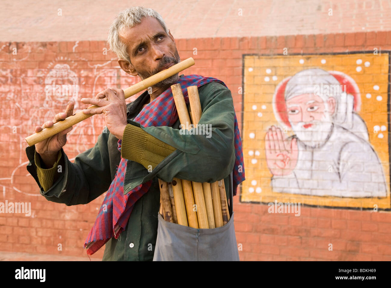 Un musicien et flûte vendeur joue de la musique par les rives de la rivière Ganga (le Gange) à Varanasi, Inde. Banque D'Images