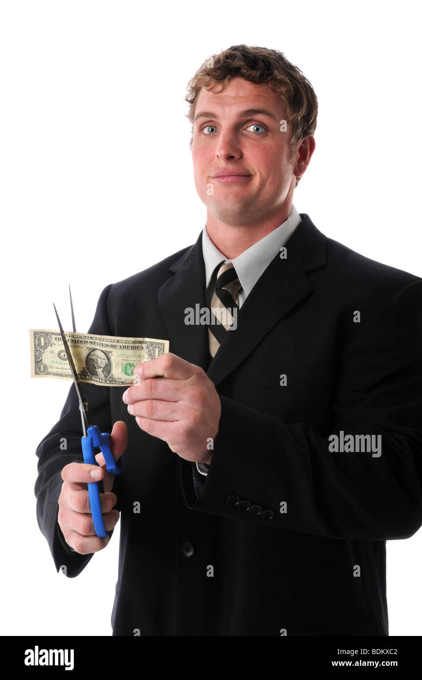 La coupe d'un homme d'affaires malheureux dollar bill avec des ciseaux Banque D'Images