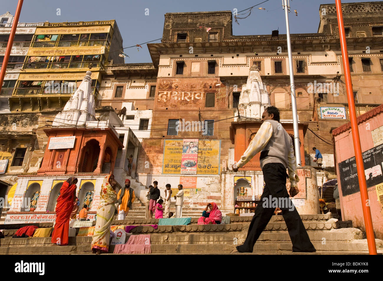 Un homme géant le long des ghats de Varanasi, en Inde. Les hommes et les femmes se lever et regarder l'homme à pied. Banque D'Images
