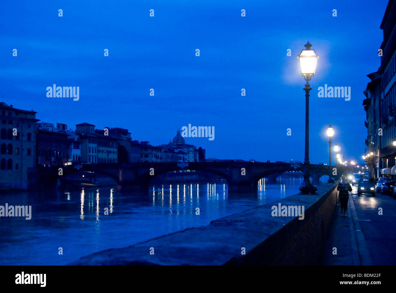 Des témoins de la rue contre un ciel de nuit à côté de la rivière Arno et le pont Santa Trinita, Florence, Italie Banque D'Images