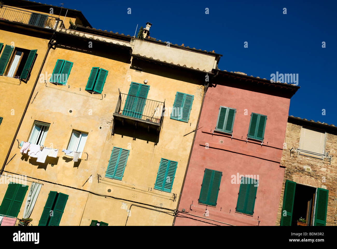 Maisons colorées avec des volets verts, Sienne, Toscane, Italie Banque D'Images