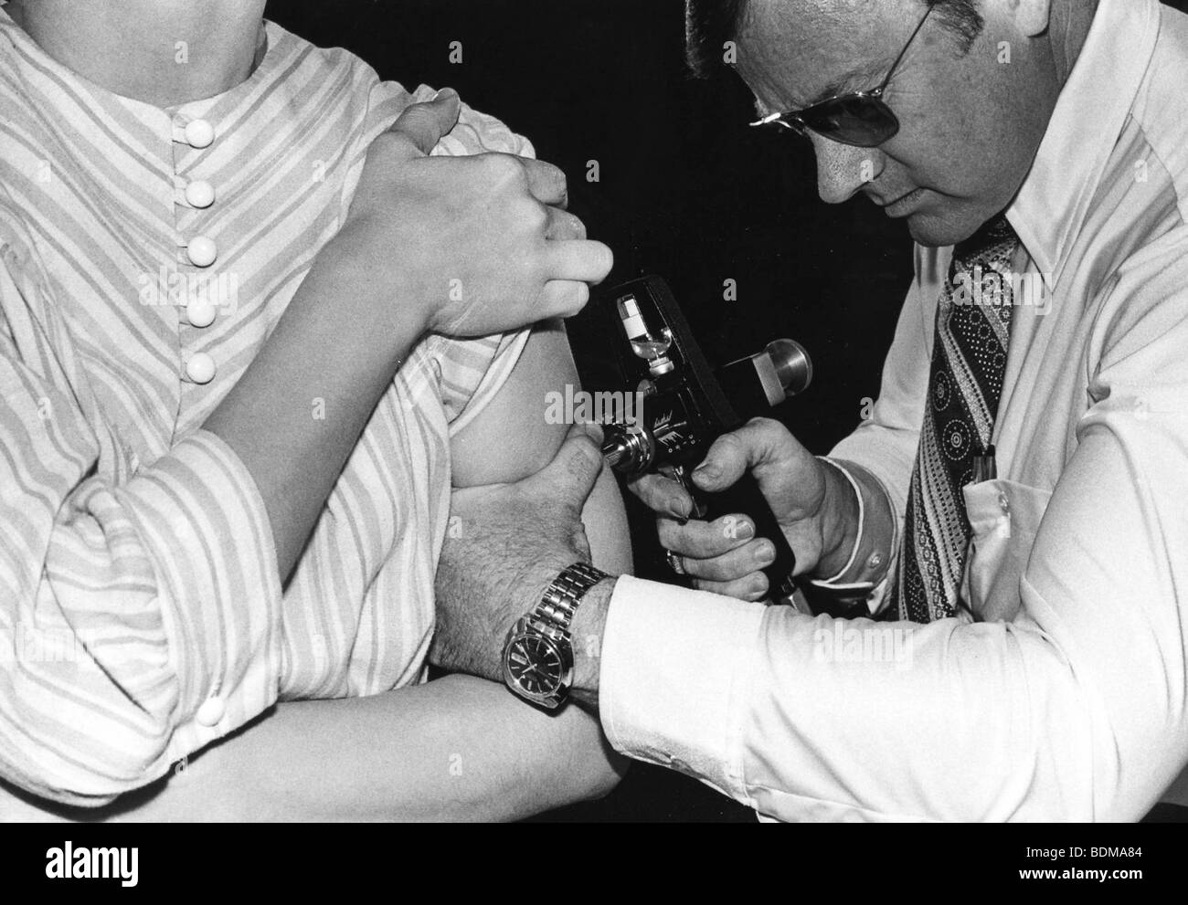 1976 Photographie d'un adulte d'être vacciné avec un jet injecteur pendant la campagne nationale de vaccination contre la grippe porcine Banque D'Images