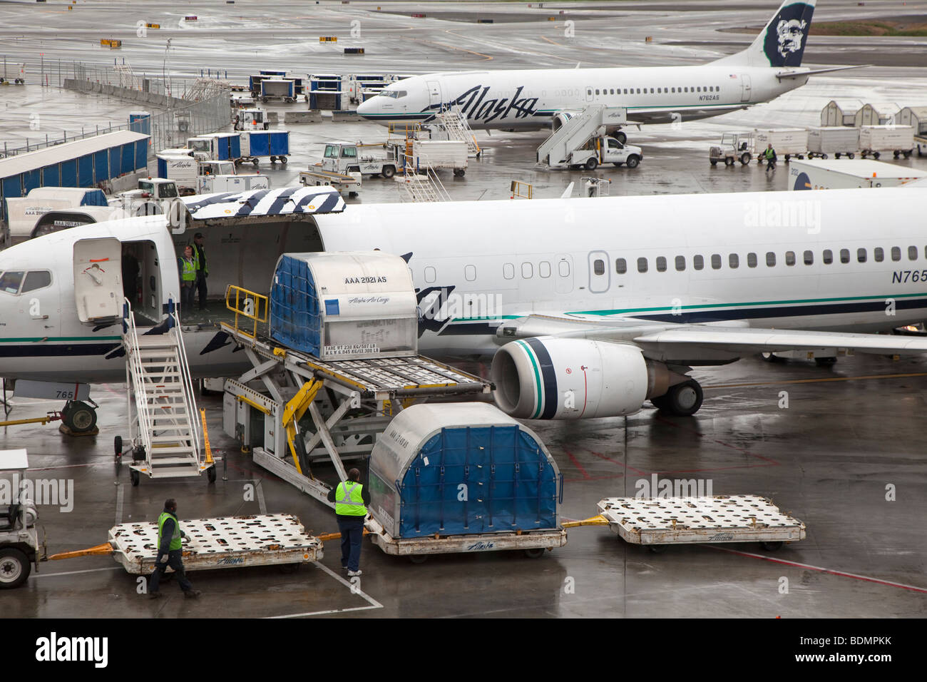 Transport de charge des travailleurs sur l'Alaska Airlines avion Banque D'Images