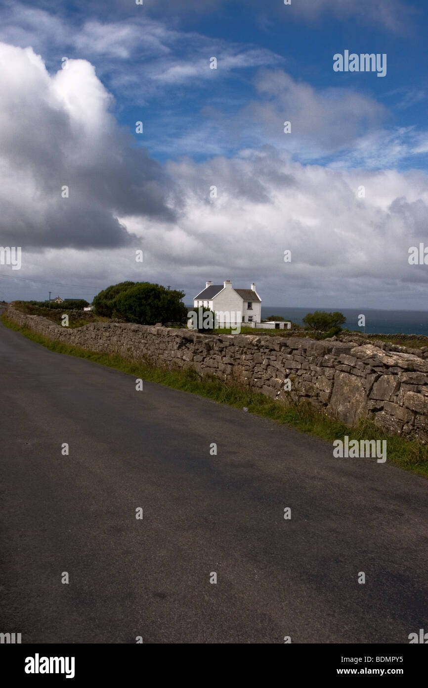 Route bordée d'Stone-Wall traditionnels, l'Inis Mor (Inismore) Island, Îles d'Aran, dans le comté de Galway, Irlande. Ciel dramatique au-dessus. Banque D'Images