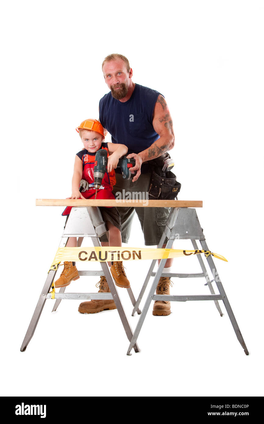 Portrait père est mignon fils d'enseignement avec casque de construction comment percer un trou dans une planche en bois, isolés. Banque D'Images