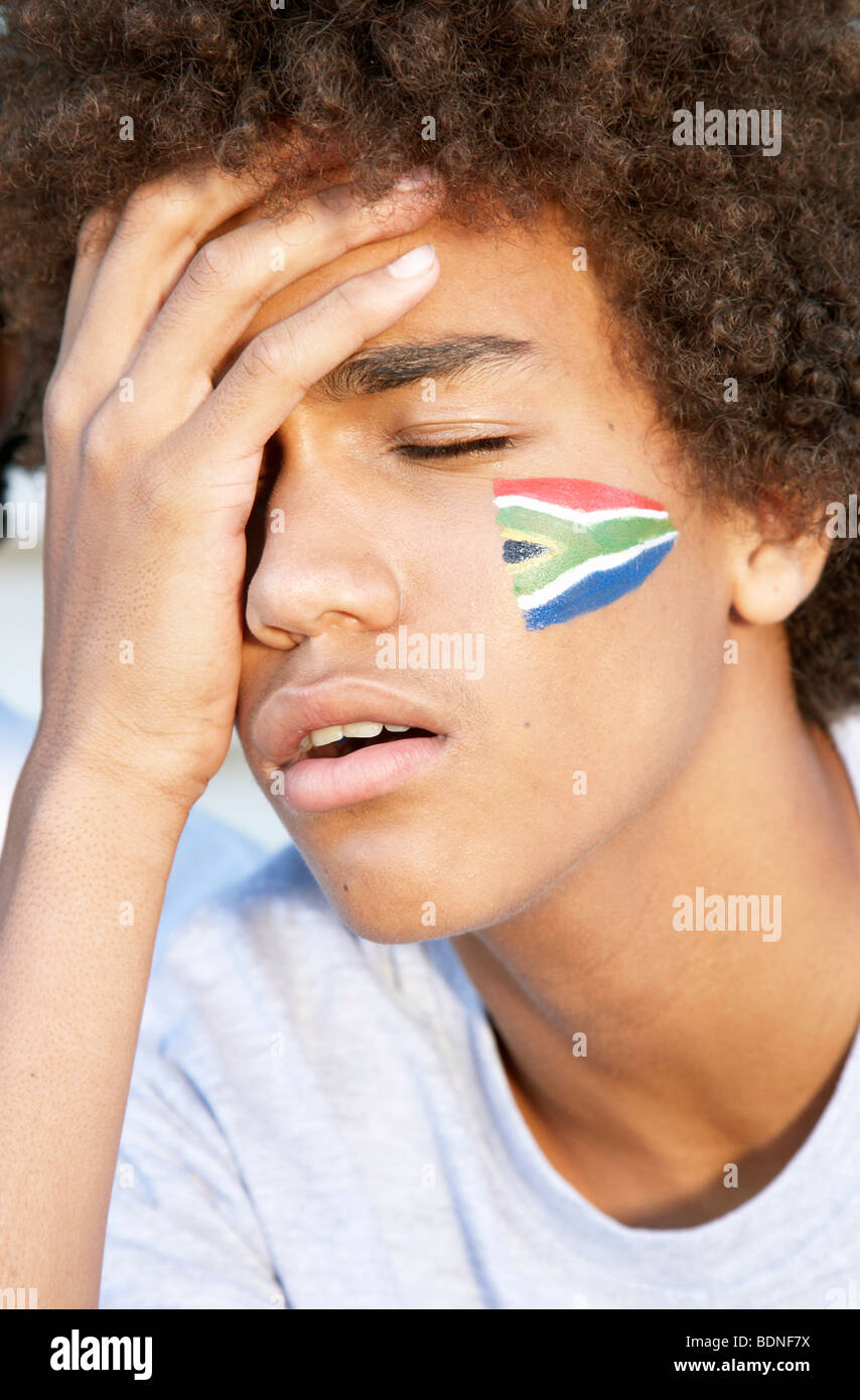 Fan de sport avec drapeau sud-africain peint sur sa joue à la déception. Cape Town, Province de Western Cape, Afrique du Sud Banque D'Images