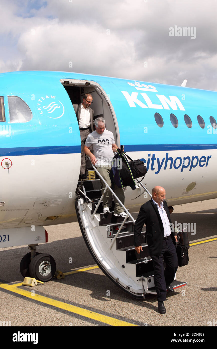 Avion de passagers KLM Fokker 70 et homme débarquer dès votre arrivée à l'aéroport Schipol d'Amsterdam 2009 Banque D'Images