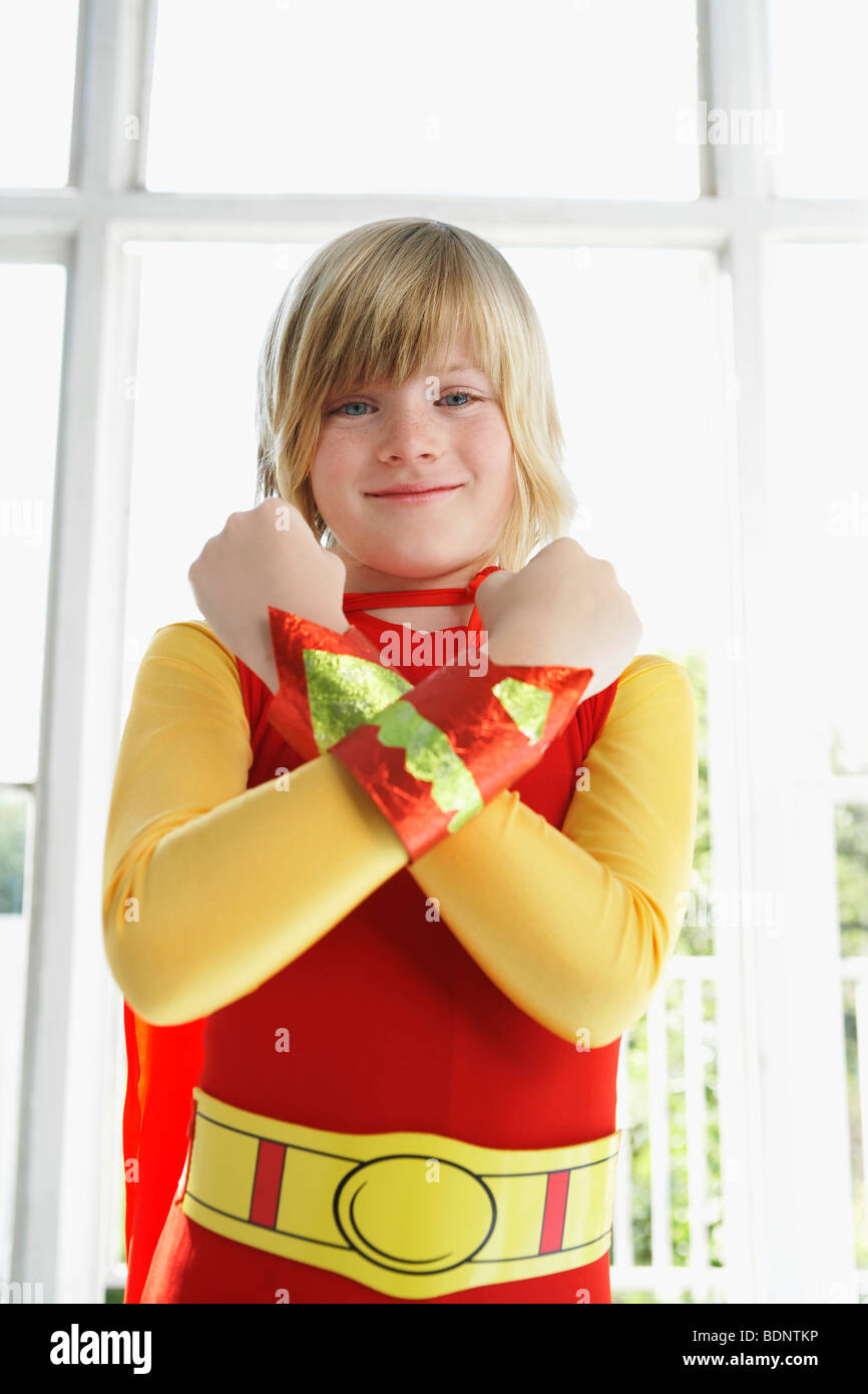 Portrait of boy (7-9) wearing superhero costume, les bras croisés, smiling Banque D'Images