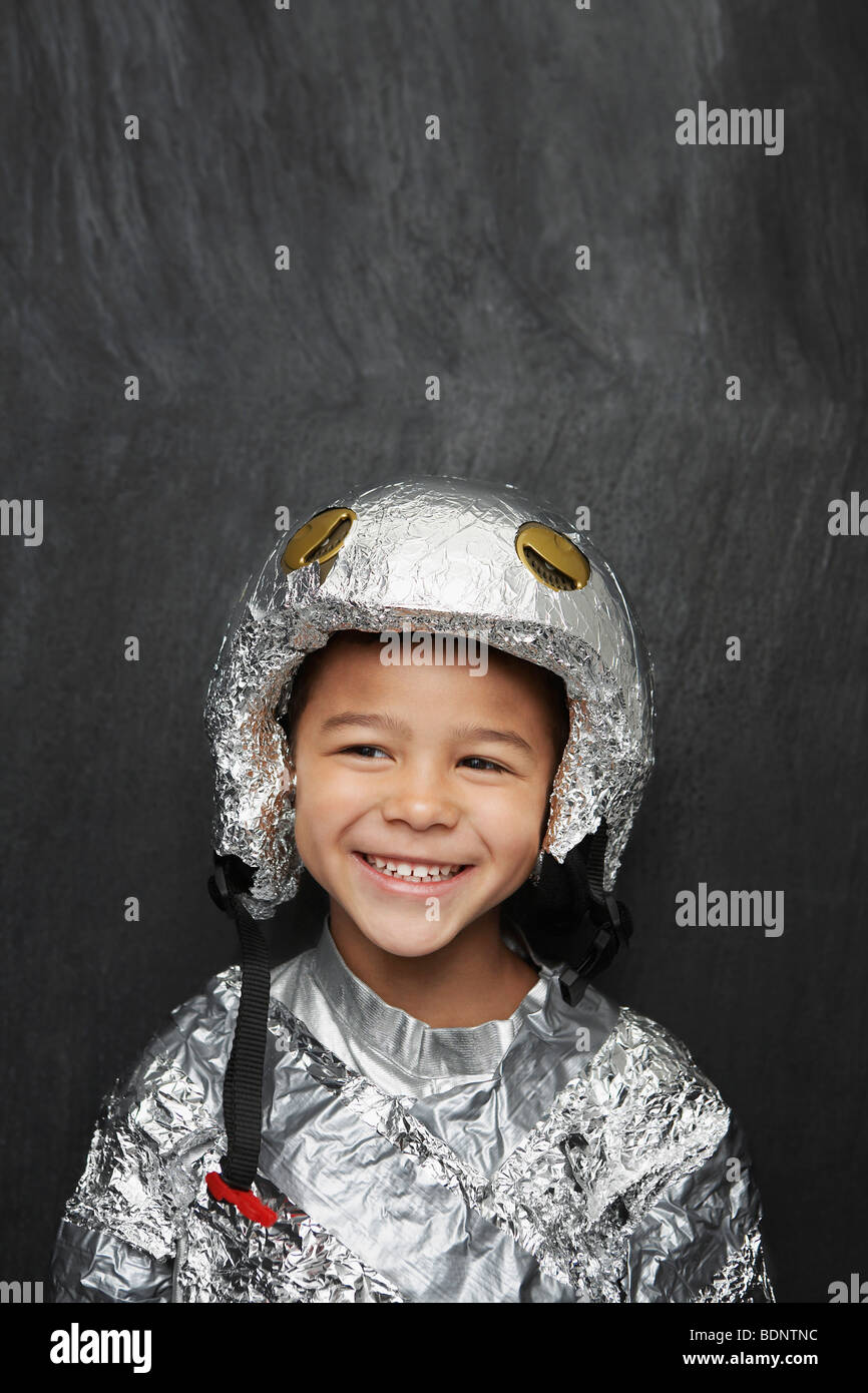 Portrait de jeune garçon (5-6) dans du papier aluminium costume astronaute, smiling, portrait Banque D'Images