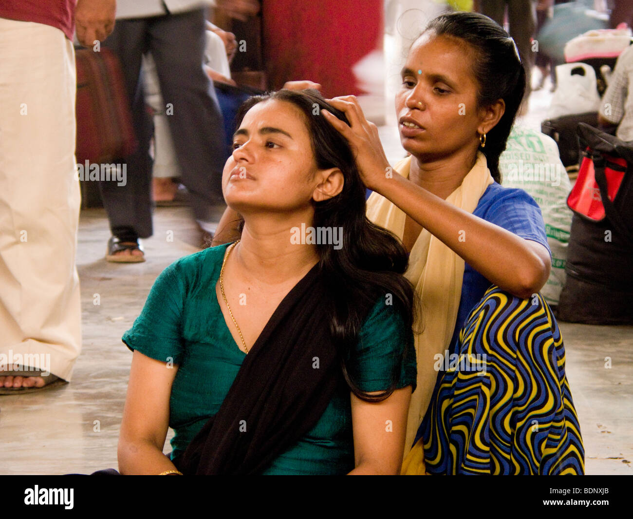 Une femme contrôle de la tête d'une fille à la gare centrale de Mumbai. Mumbai. L'Inde. Banque D'Images