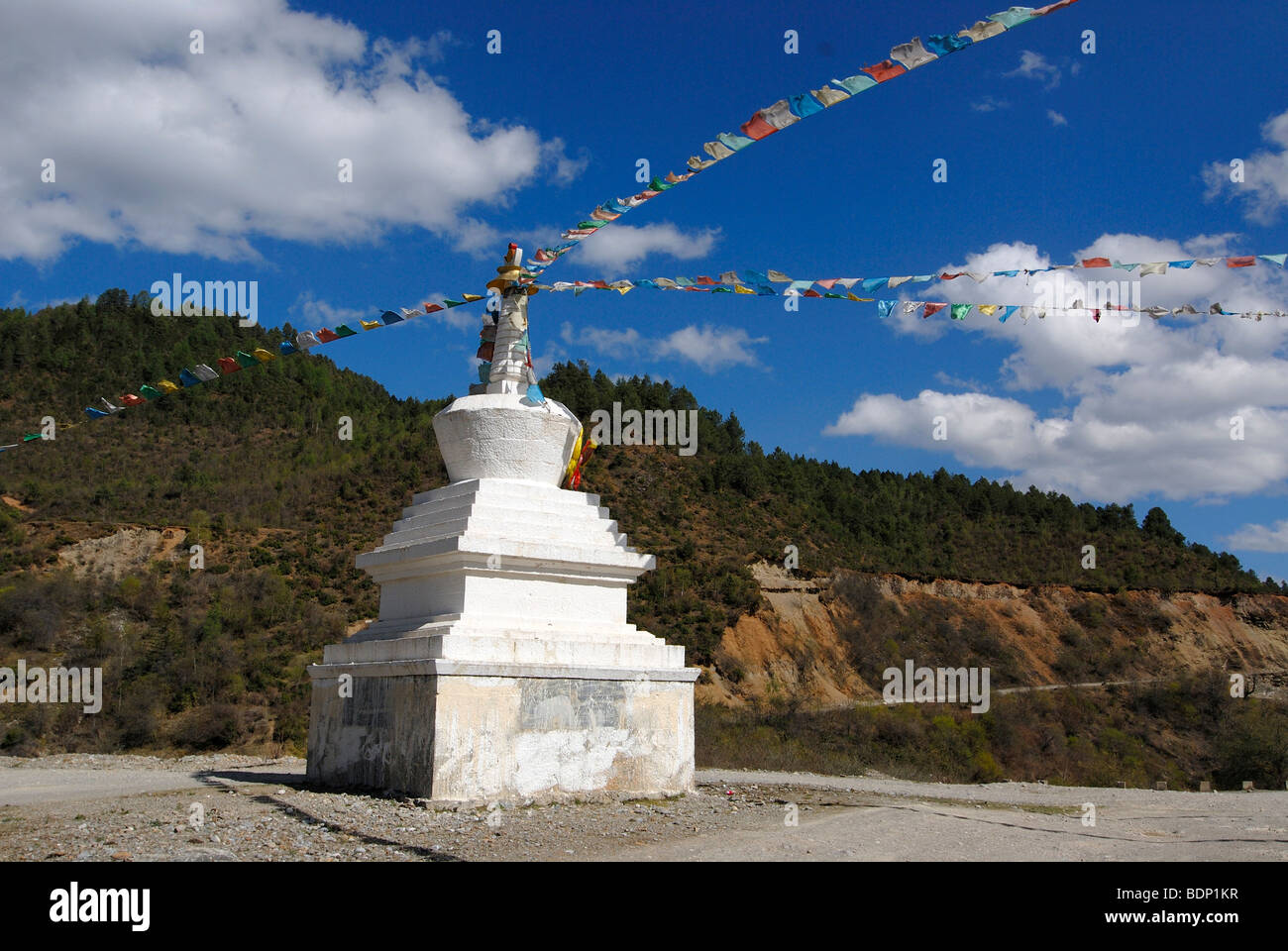 Stupa avec drapeaux de prière Tibetains en face des forêts de montagne dans l'est du Tibet, Gyelthang, Zongdian, Shangrila, Yunnan, Tibet, C Banque D'Images