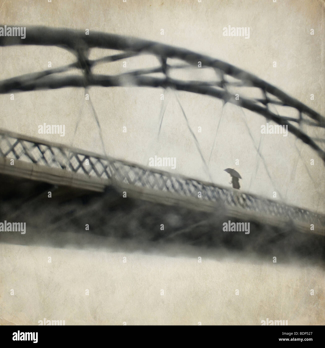Un homme de traverser un pont sur un jour de pluie Banque D'Images