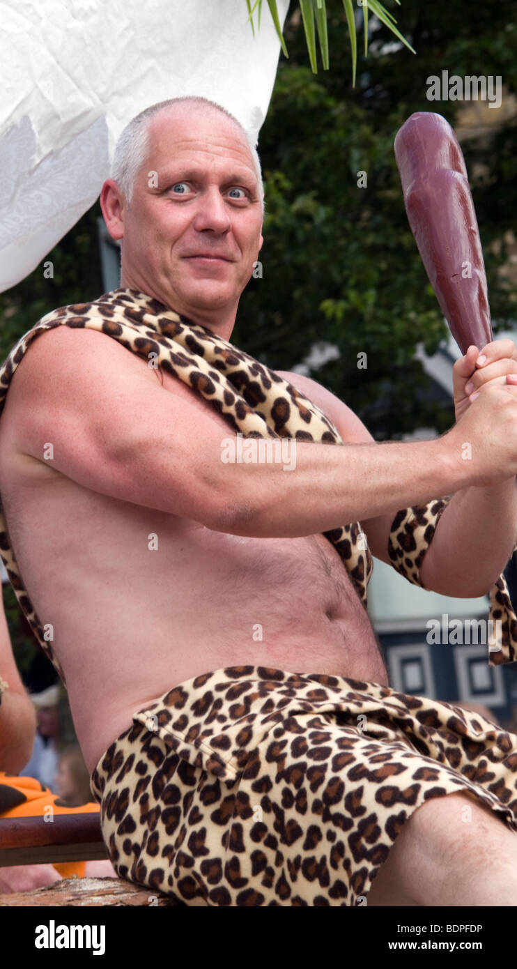 Homme vêtu comme un homme des cavernes tenant un club et smiling in fancy dress parade Bakewell Derbyshire Banque D'Images
