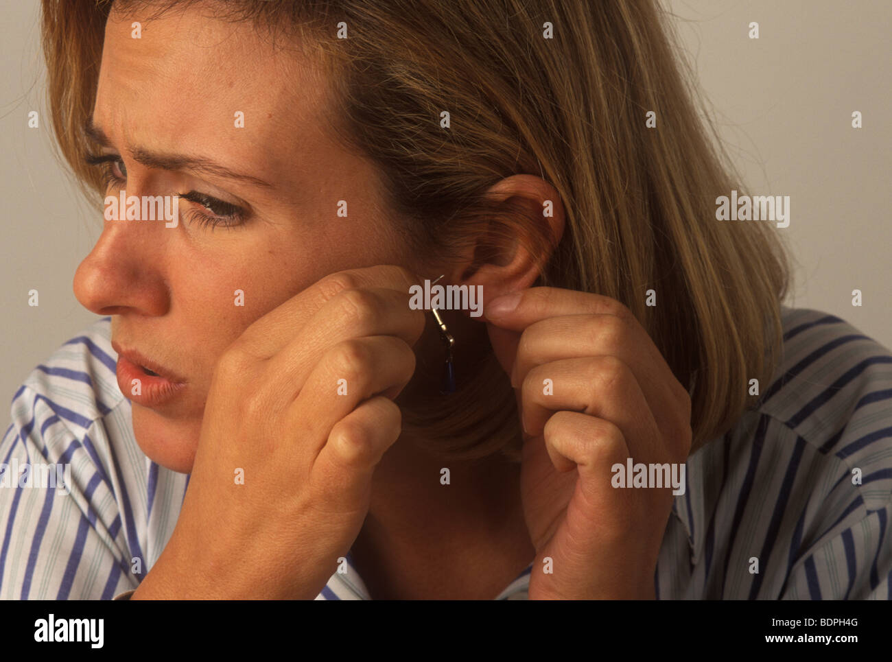 Femme avec une inflammation de l'oreille qui démange souffrant d'une  allergie au nickel Photo Stock - Alamy