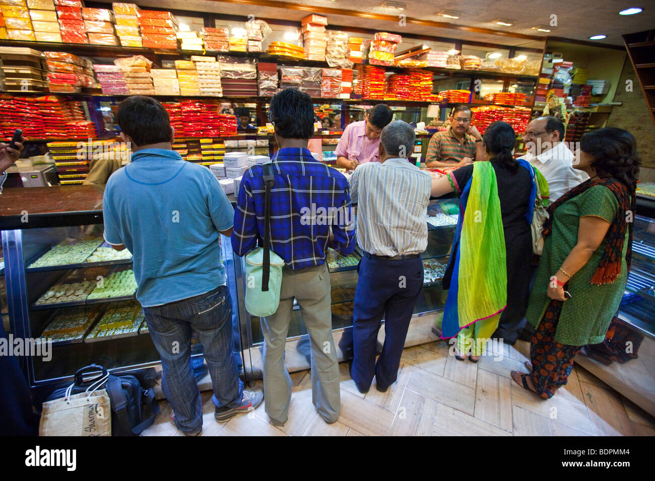 Les clients d'une boutique de bonbons de Calcutta, Inde Banque D'Images