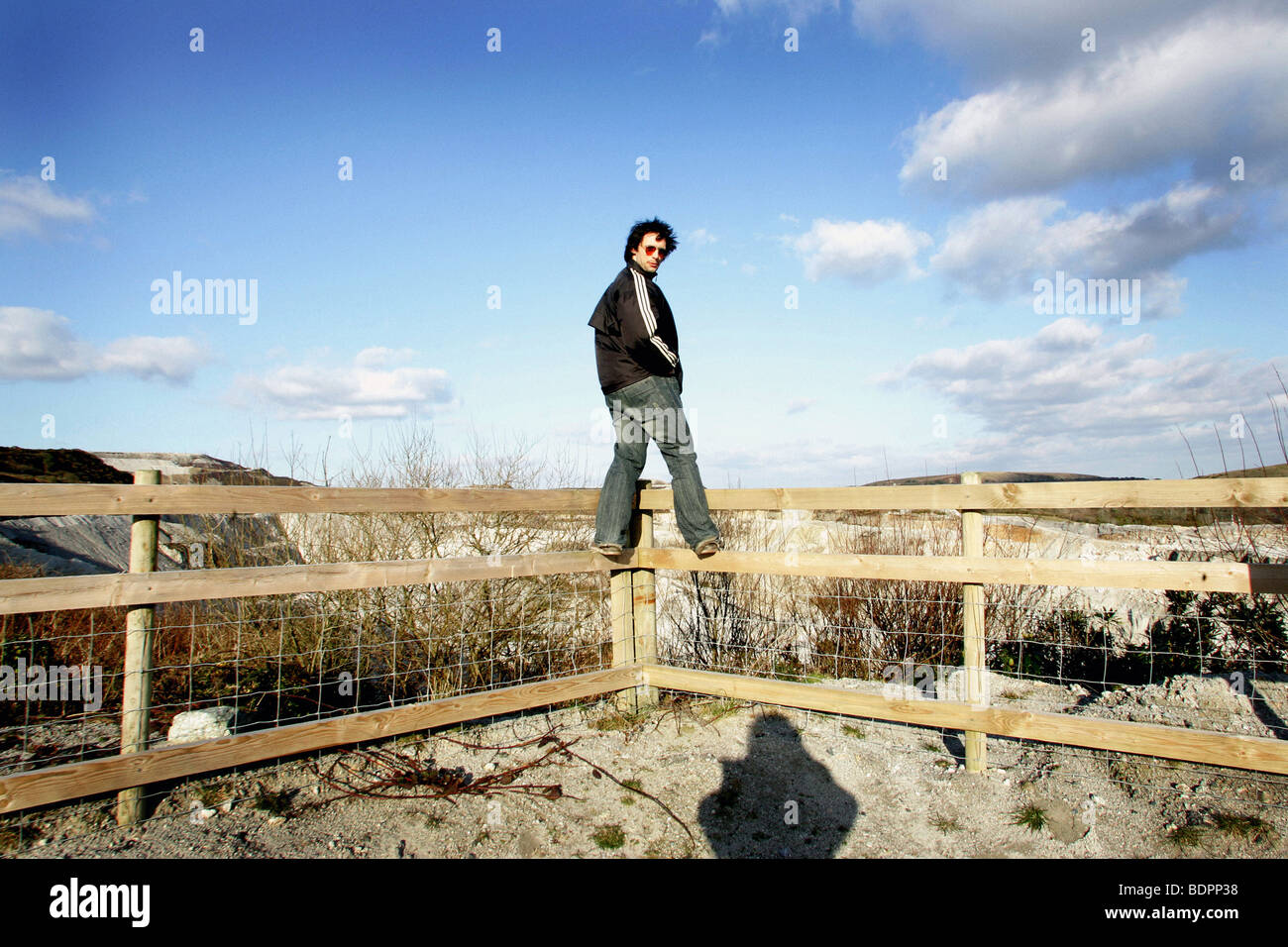 Homme debout sur la clôture à la caméra à l'arrière Banque D'Images