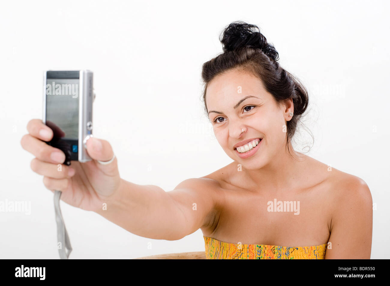 Les femmes prenant sa propre photo avec cellphone over white Banque D'Images