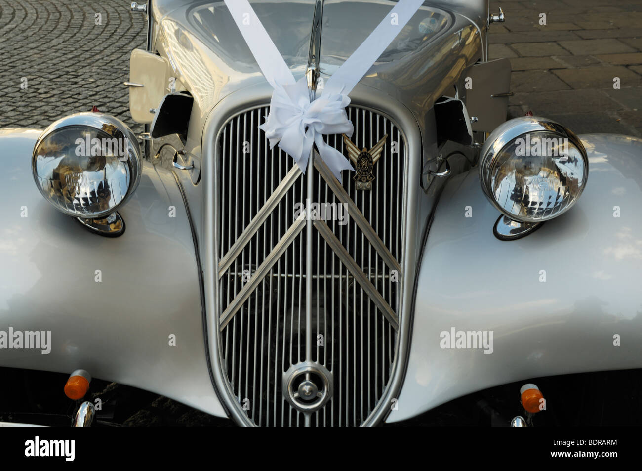 L'avant d'un argent entièrement restauré Citroen Traction Avant Légère utilisée comme voiture de mariage avec ruban blanc. Banque D'Images