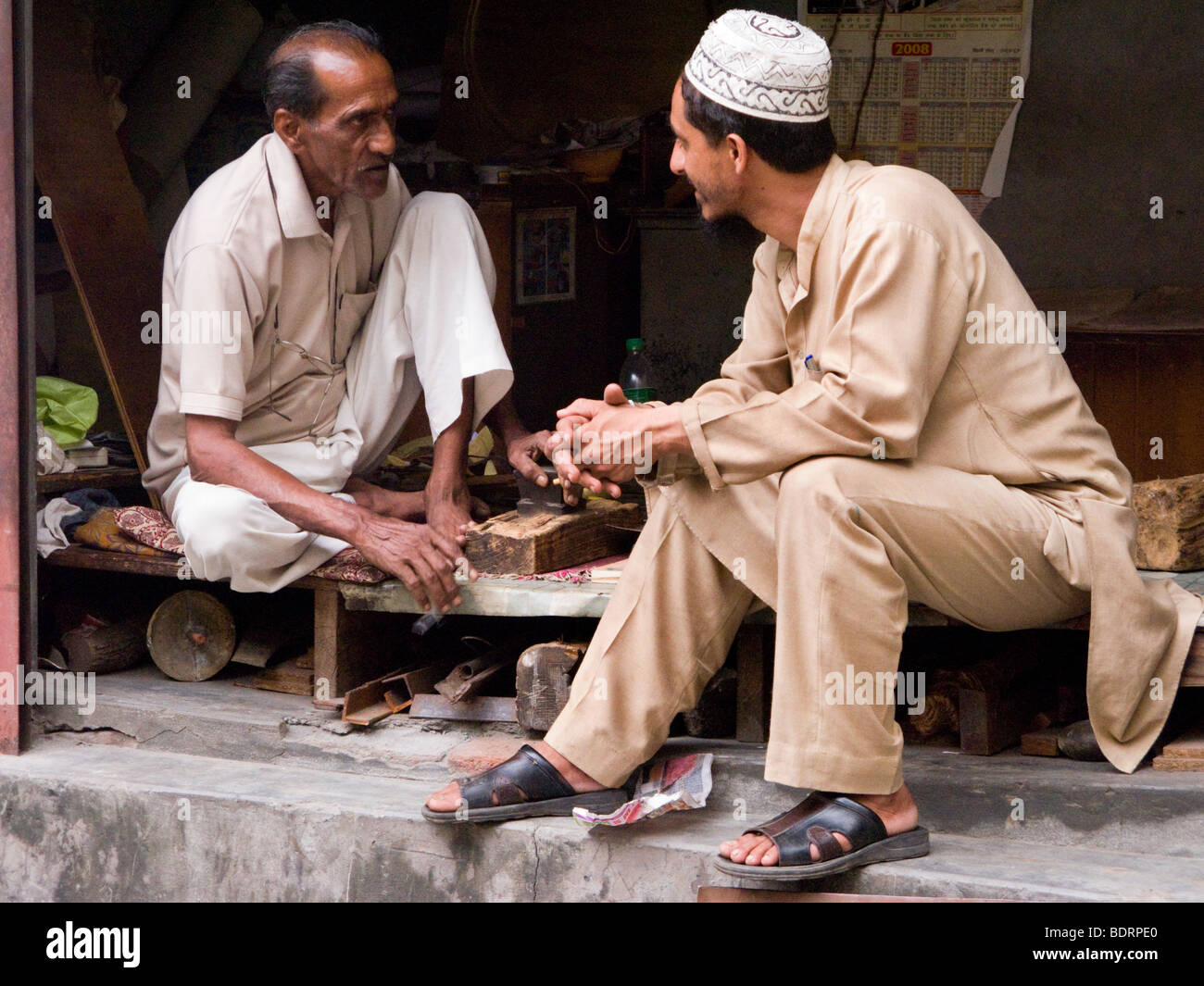 Les hommes indiens discutent dans une boutique d'une façade maison. Chamba, Himachal Pradesh. L'Inde. Banque D'Images