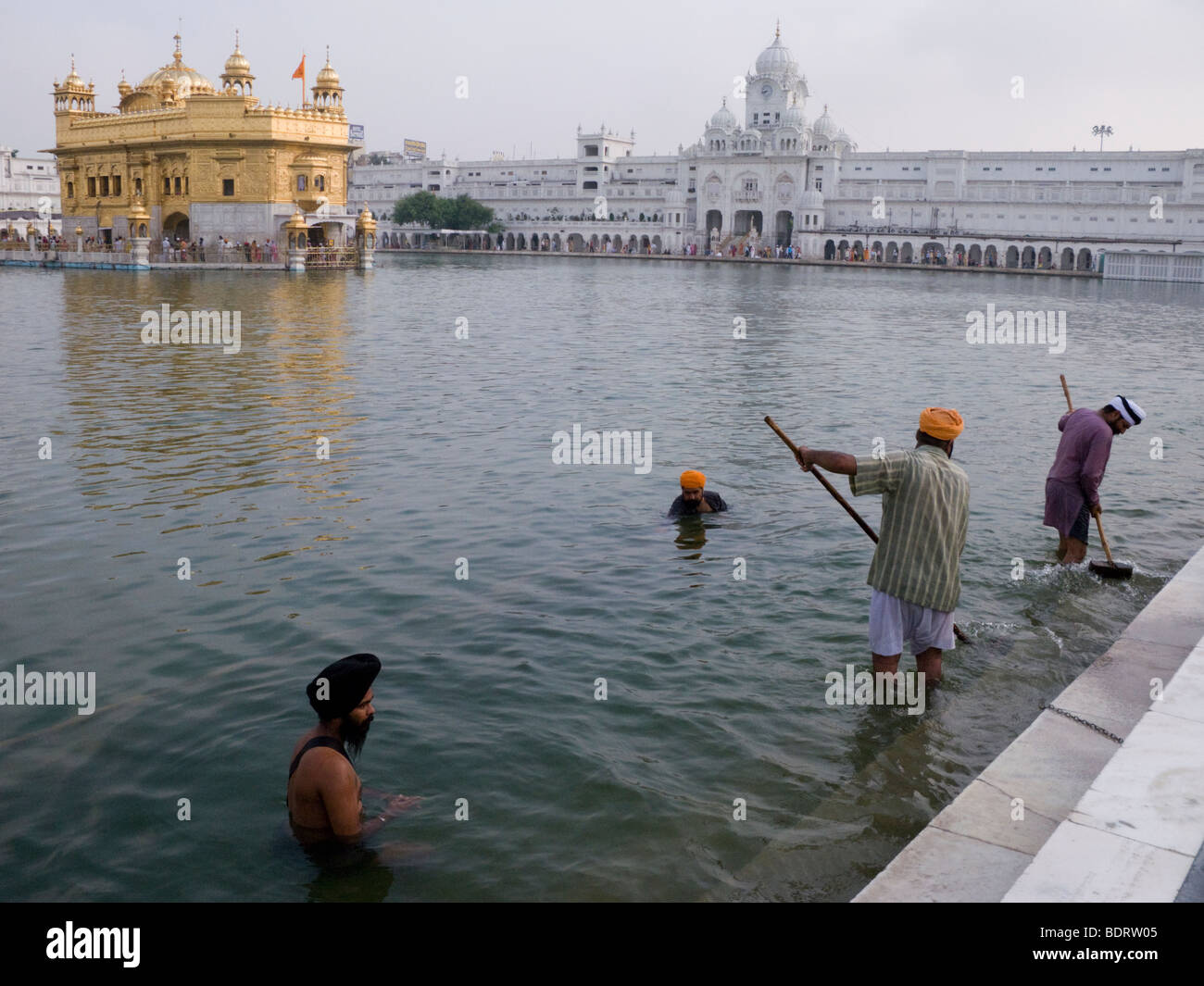 Nettoyer les Sikhs Sarovar (réservoir d'eau) - autour du Temple d'Or (Sri Harmandir Sahib) ; d'autres se baignent. Amritsar. Punjab. L'Inde. Banque D'Images