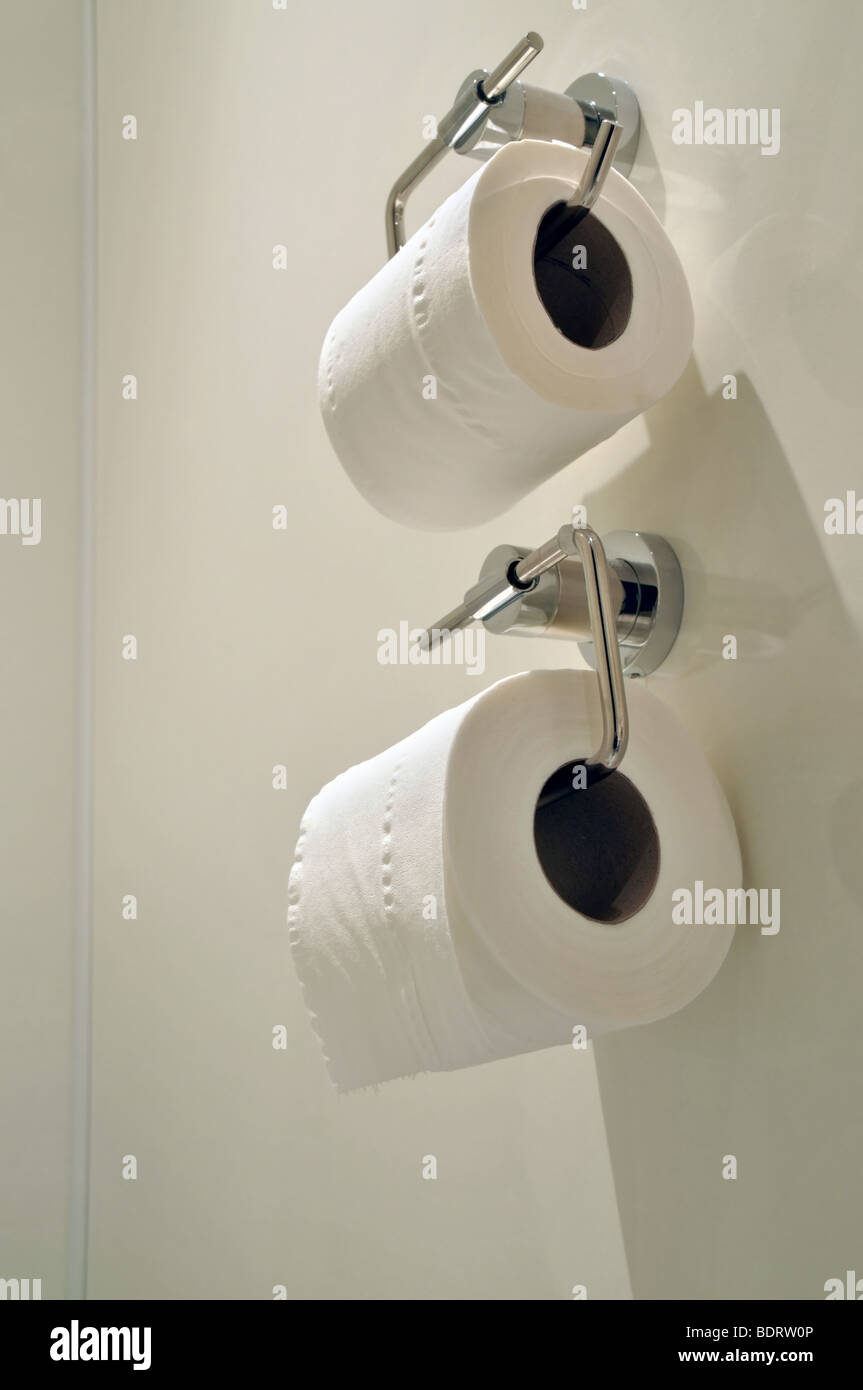Deux titulaires de papier toilette mural fixe, avec des rouleaux de papier wc blanc. Banque D'Images