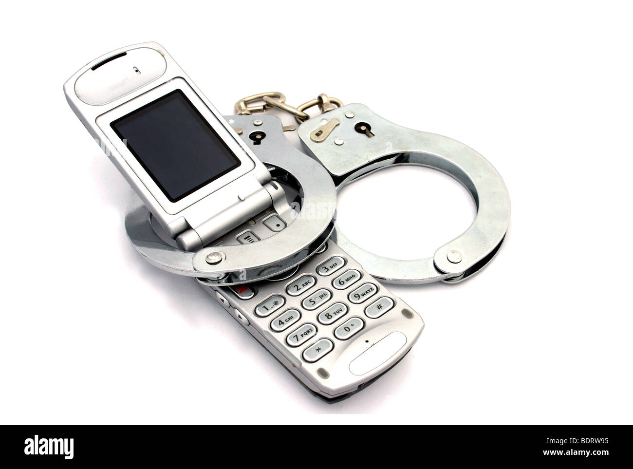 Vieux téléphone cellulaire avec des menottes pour illustrer les gens qui ne peuvent pas survivre sans leur téléphone mobile Banque D'Images