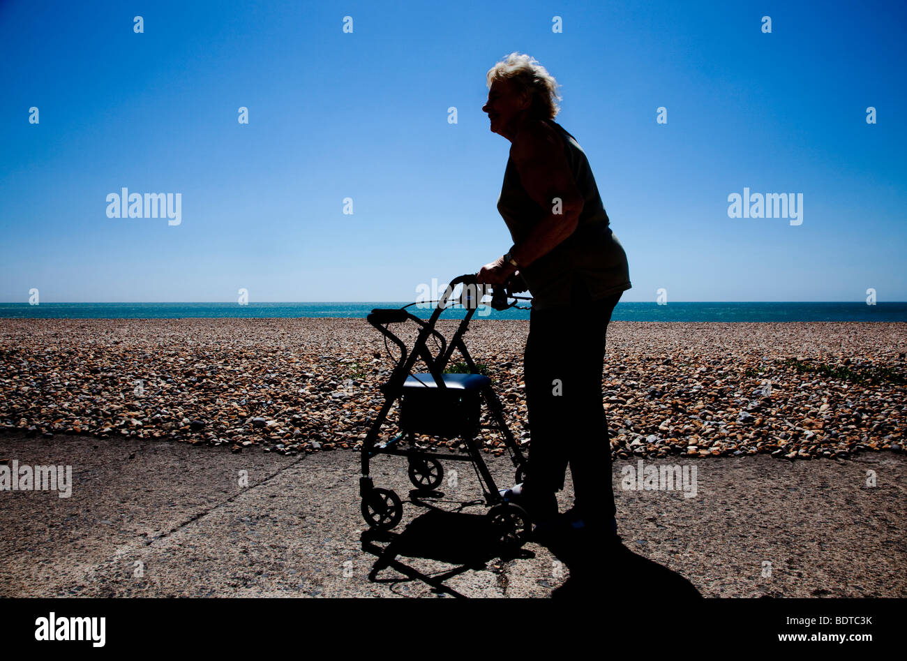 Femme âgée avec déambulateur sur front de mer Banque D'Images