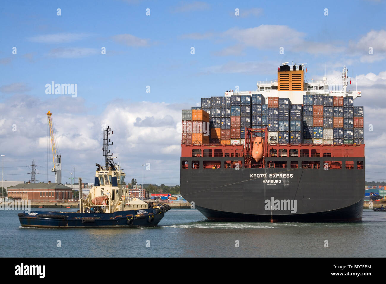Porte-conteneurs Express Kyoto être transformé par un remorqueur à Southampton docks Banque D'Images
