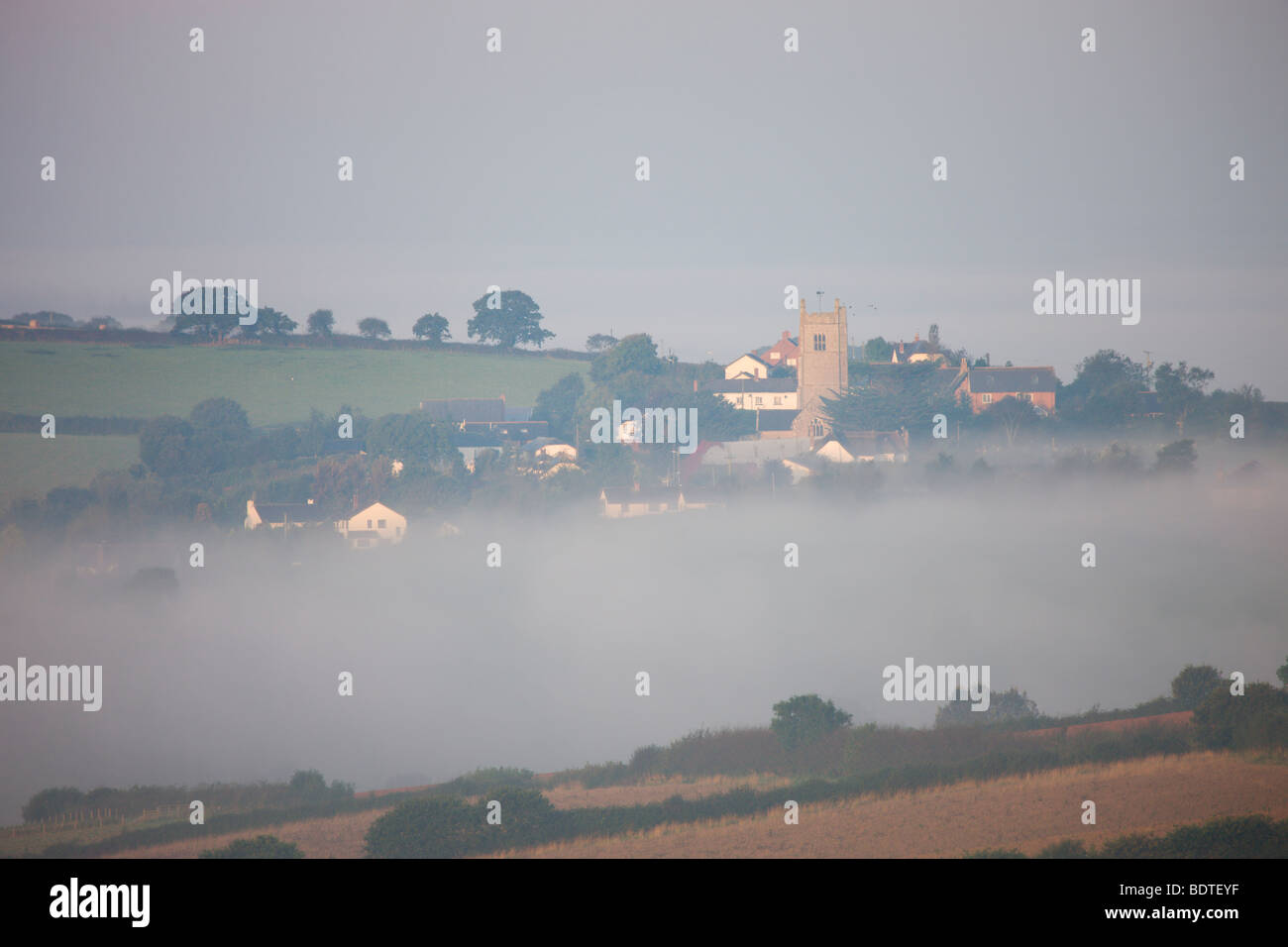 Colebrooke village et église entourée de brume, Devon, Angleterre. L'été (septembre) 2008 Banque D'Images