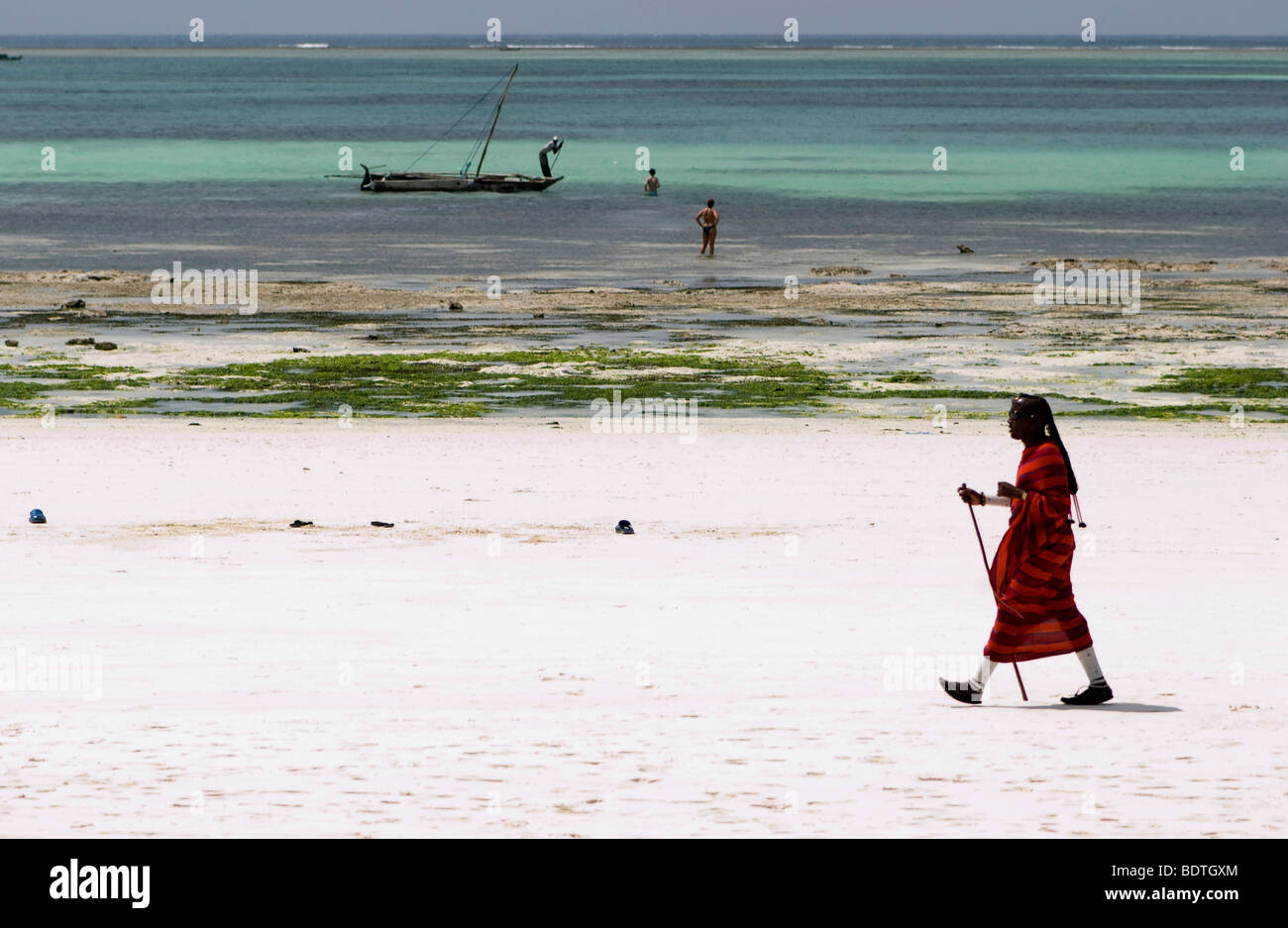 Jeune guerrier masai walking on the beach Banque D'Images Jeune guerrier masai walking on the beach Banque D'Images