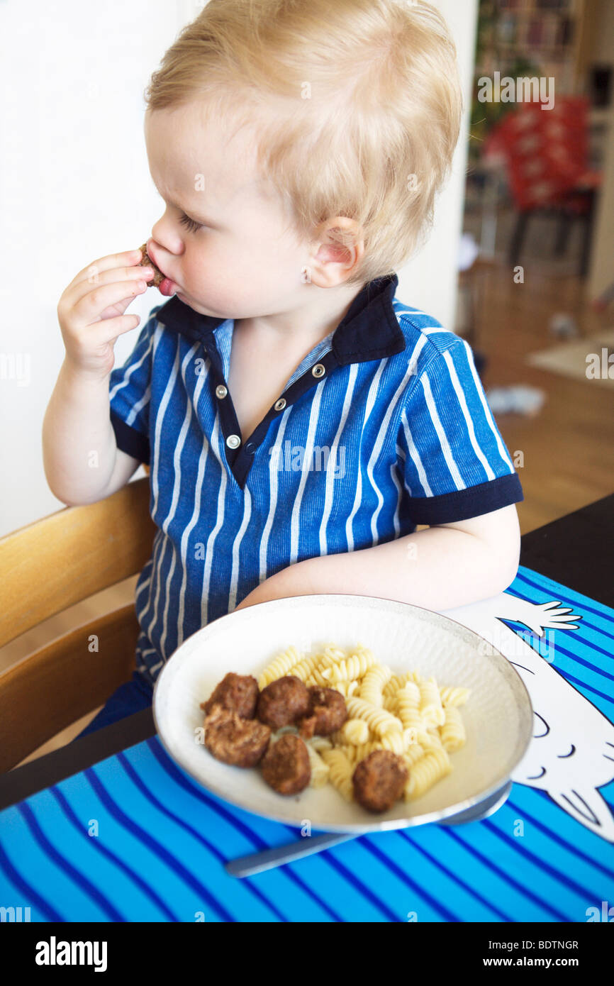 Un garçon de manger des boulettes de viande Banque D'Images