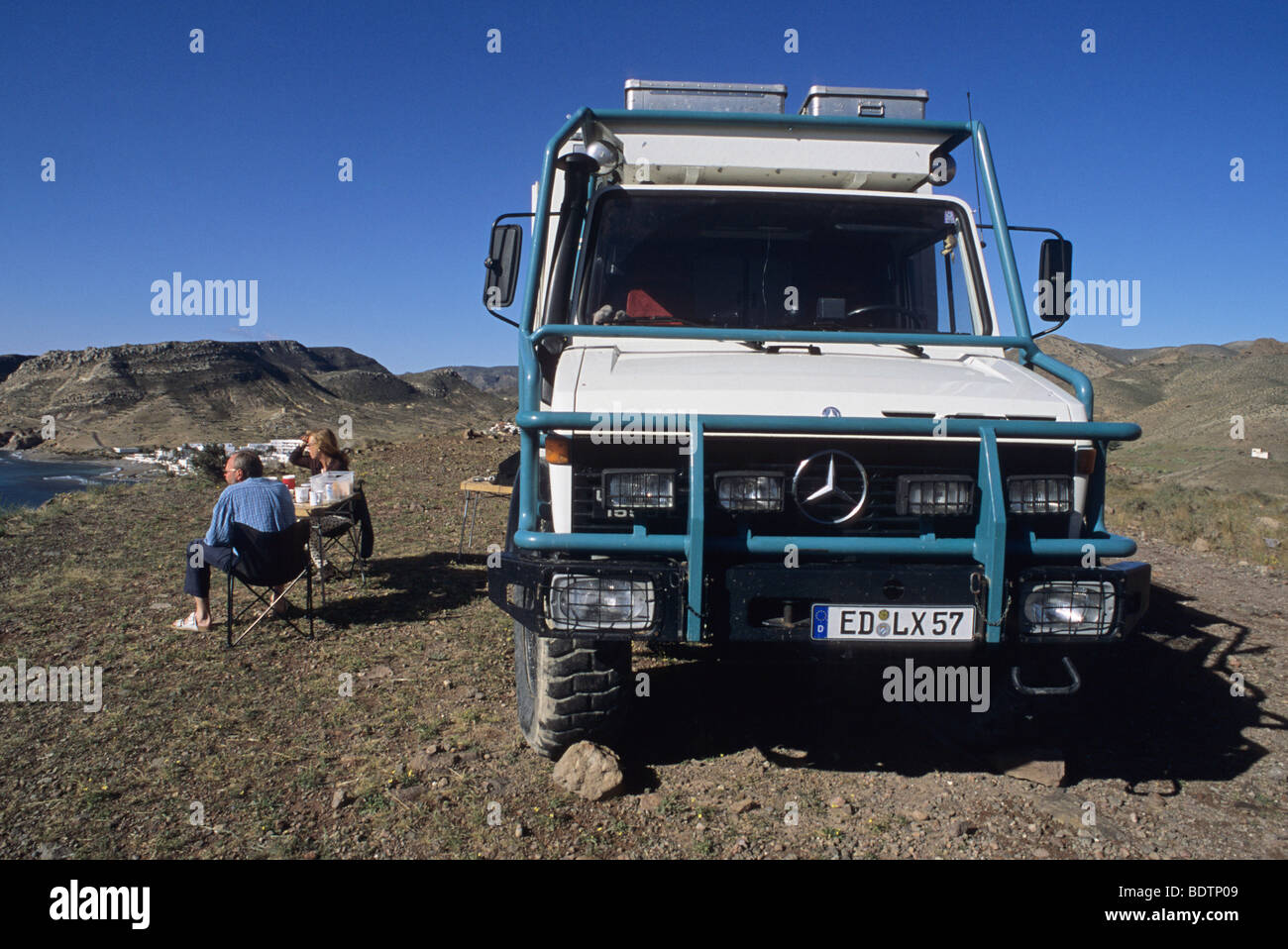 4x4 Jeep et couple de touristes dans la région de Agua Amarga, parc naturel de Cabo de Gata, Espagne Banque D'Images