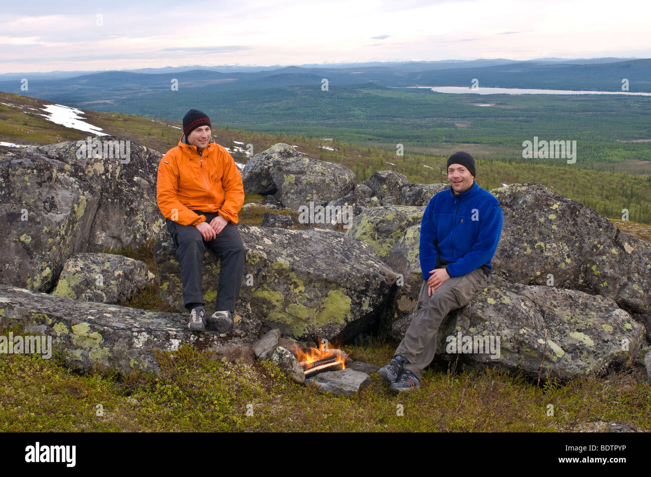 Les hommes sont sur le gril à un bon feu de fjell, Laponie suédoise Banque D'Images