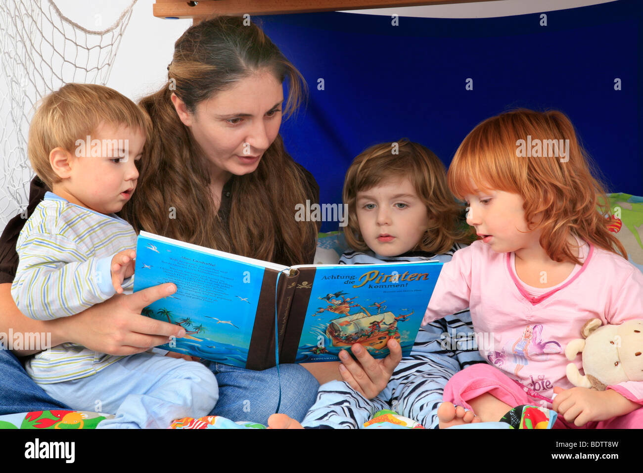 La lecture d'un livre sur les pirates à ses enfants dans une Billi-Bolli lit en mezzanine Banque D'Images