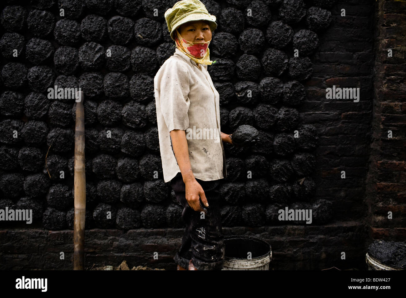 Une femme fait le charbon galettes dans Village Bat Trang, Hanoi, Vietnam. Banque D'Images